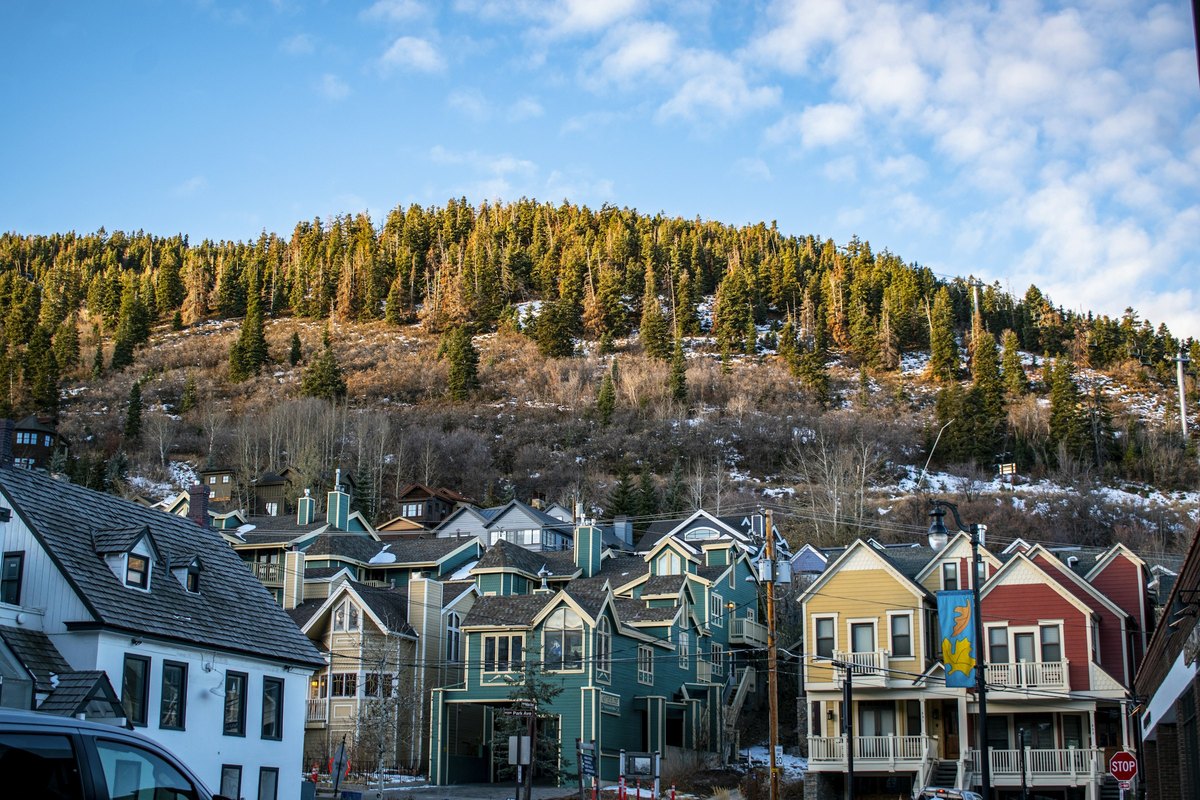 Colorful neighborhood homes along a Park City street with a mountain hillside behind them